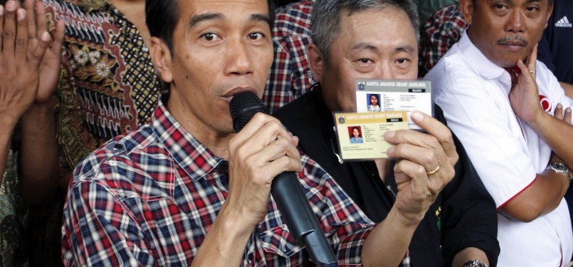 Calon Gubernur Joko Widodo memperlihatkan kartu sehat dan kartu pendidikan, di Jalan Gajah Mada-Hayam Wuruk, Ahad (1/3). (Republika/Adhi Wicaksono)