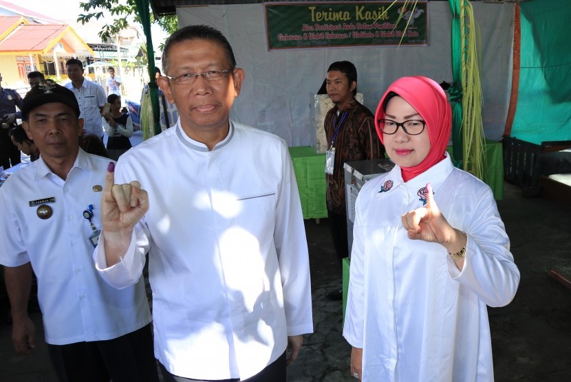 Calon Gubernur Kalbar, Sutarmidji (kedua kiri) bersama istri memperlihatkan jari kelingking bertinta biru usai pencoblosan Pilgub Kalbar di TPS 006, Kelurahan Sungai Beliung, Pontianak, Rabu (27/6).