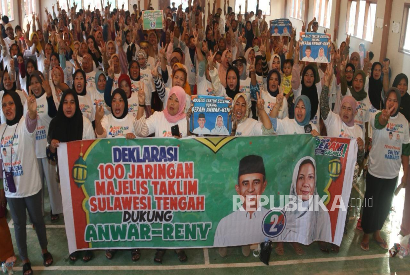 Calon Gubernur Sulawesi Tengah Anwar Hafid dan Calon Wakil Gubernur Reny Lamadjido berfoto bersama anggota majelis taklim.