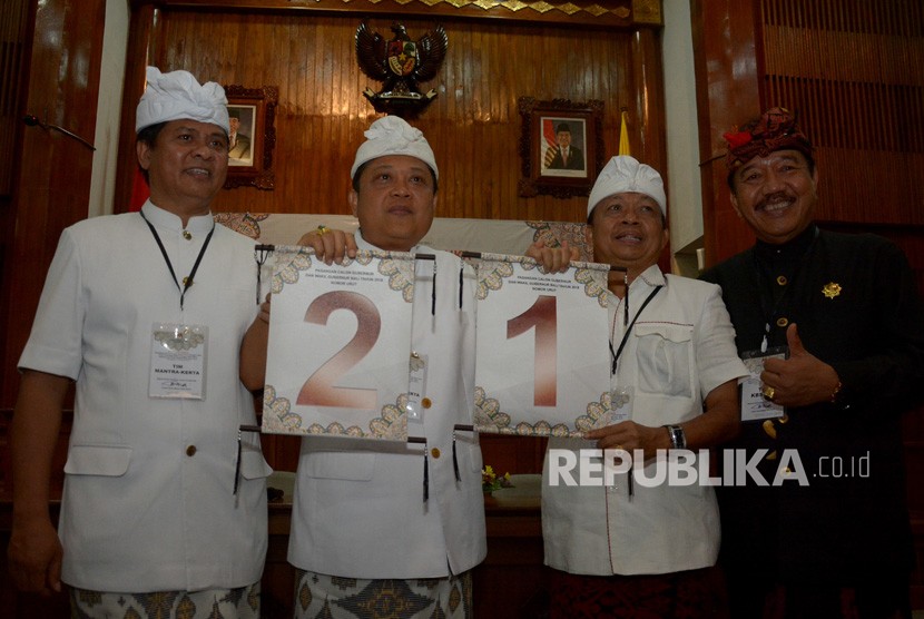 Calon Gubernur/Wagub Bali Ida Bagus Rai Dharmawijaya Mantra (kedua kiri)-Ketut Sudikerta (kiri) dan Wayan Koster (kedua kanan)-Tjokorda Oka Artha Ardana Sukawati (kanan) menunjukkan nomor urut masing-masing saat rapat pleno pengundian nomor urut di kantor Gubernur Bali, Denpasar, Bali, Selasa (13/2). 