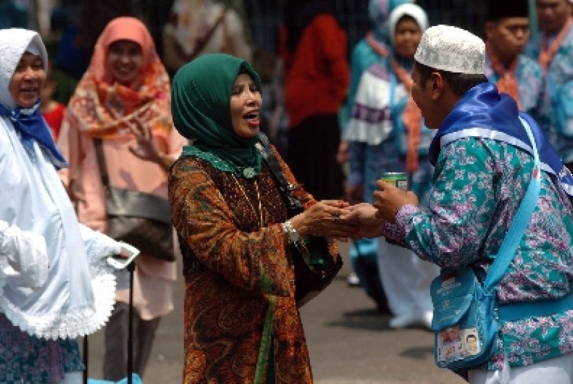 Calon haji bersalaman dengan kerabatnya sebelum berangkat ke Tanah Suci Makkah.