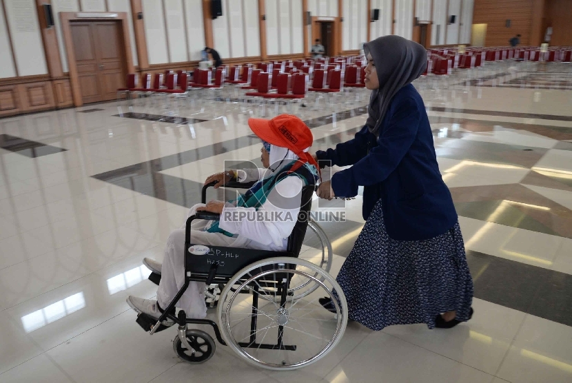 Calon Haji difabel berjalan dengan bantun petugas saat berada di Asrama Haji Pondok Gede, Jakarta, Selasa (8/9).  (Republika/Yasin Habibi)