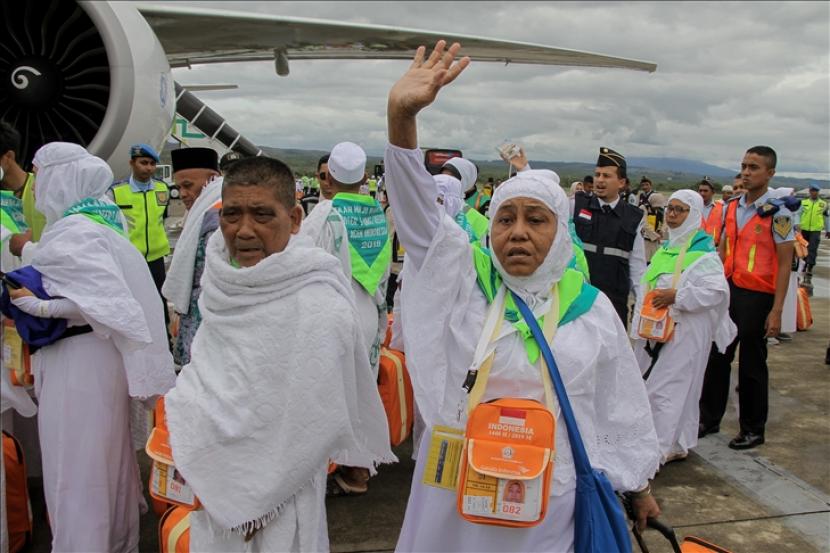 Calon haji melambaikan tangan kepada keluarga di Bandara Sultan Iskandar Muda, Aceh Besar, Aceh, Indonesia, Sabtu 20 Juni 2019.