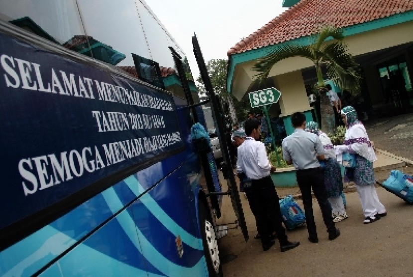 Calon jamaah haji kelompok terbang (kloter) 13 asal DKI Jakarta berjalan menuju bus saat pemberangkatan di Asrama Haji Pondok Gede, Jakarta,