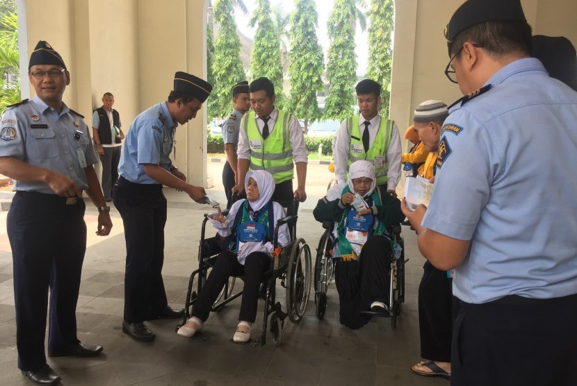 Calon jamaah haji kloter 20 asal Serang, Banten, Eti Suhaeti (64 tahun) (kanan) saat akan bertolak ke bandara di Asrama Haji Pondok Gede, Kamis (26/7). 