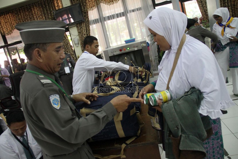    Calon jamaah haji kloter 3 Embarkasi Bekasi melakukan pemeriksaan barang saat pemberangkatan dari Asrama Haji Bekasi, Jawa Barat, Rabu (11/9). (Republika/Yasin Habibi)