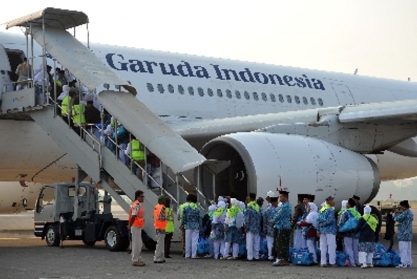  Calon jamaah haji kloter pertama embarkasi Solo menaiki pesawat maskapai Garuda Indonesia untuk diterbangkan ke Jeddah, Arab Saudi, di Bandara Adi Soemarmo, Solo,