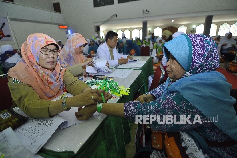  Calon jamaah haji kloter satu melakukan cek kesehatan sebelum bersiap untuk berangkat ke tanah suci di Asrama Haji Pondok Gede, Jakarta, Kamis (27/7). 