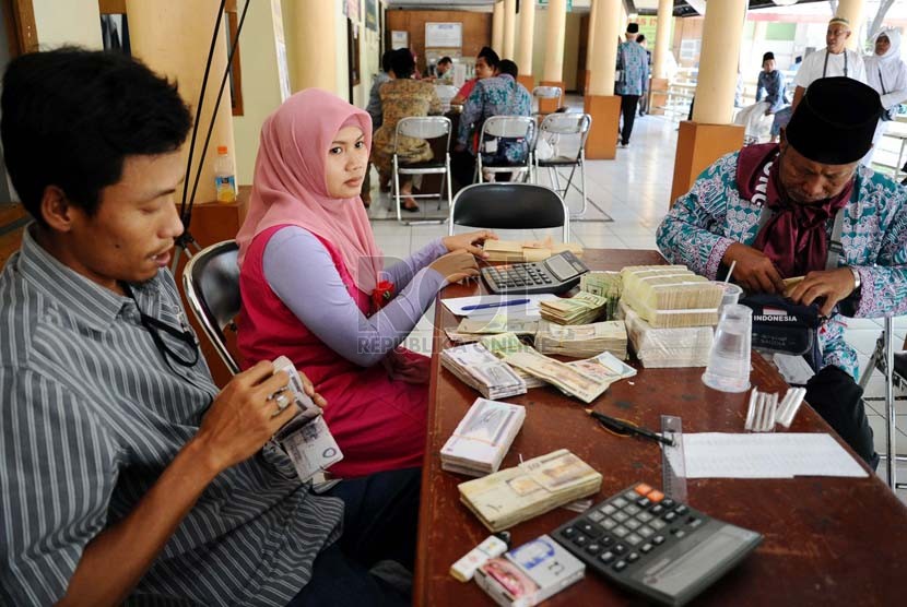 Calon jamaah haji menukarkan uang rupiah dipenukaran asrama haji, Bekasi, Jawa Barat, Kamis (18/9).(Republika/ Tahta Aidilla)