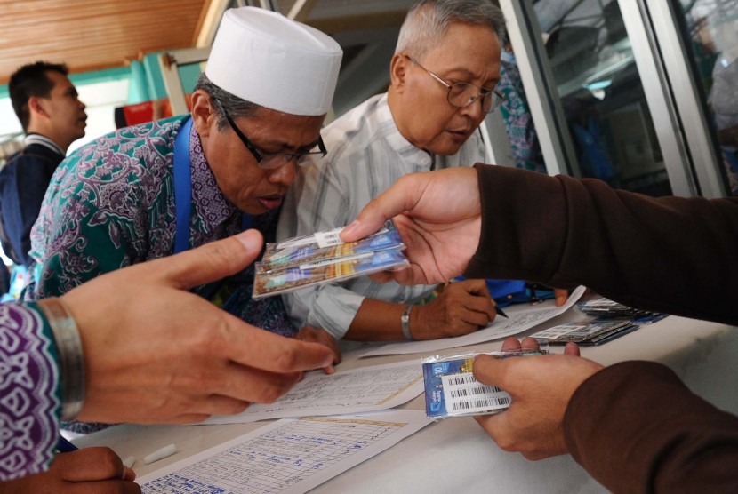 Calon jamaah haji sedang mengisi registrasi saat akan menerima kartu perdana seluler di asrama haji Pondok Gede, Jakarta. Mereka mendapatkan kartu selular secara cuma-cuma yang akan digunakan di Tanah Suci untuk mempermudah komunikasi.