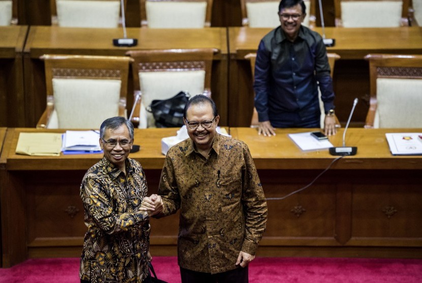 Calon Ketua Otoritas Jasa Keuangan (OJK) Wimboh Santoso (kiri) dan Sigit Pramono (kedua kiri) berjabat tangan di sela-sela uji kepatutan dan kelayakan calon Ketua Dewan Komisioner Otoritas Jasa Keuangan (OJK) di Komisi XI DPR, Kompleks Parlemen, Senayan, Jakarta, Senin (5/6).