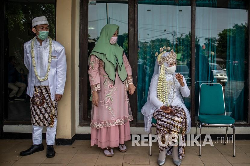 Calon pasangan pengantin menggunakan masker saat menunggu giliran untuk mengikuti prosesi akad nikah 