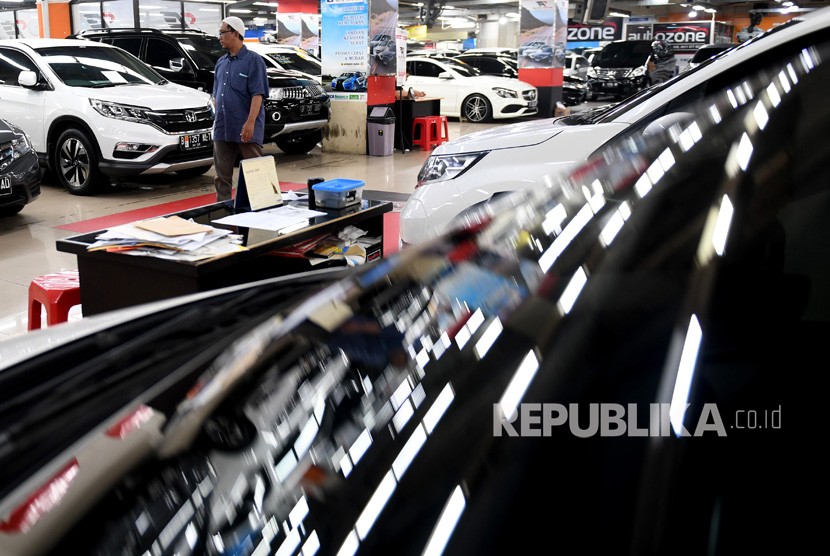 Calon pembeli berjalan melintasi deretan mobil bekas yang dijual di bursa mobil bekas, WTC Mangga Dua, Jakarta, Jumat (9/8/2019).