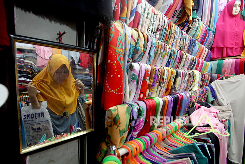 Calon pembeli memilih pakaian muslim saat berbelanja di salah satu toko di Pasar Cibinong, Kabupaten Bogor, Jawa Barat. Pandemi Covid-19 telah membuat nilai belanja produk busana muslim cukup terdampak dan mengalami penurunan besar 2,9 persen.  