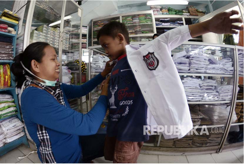 Calon pembeli mencoba baju seragam sekolah yang dijual di salah satu toko di Bandar Lampung, Lampung.
