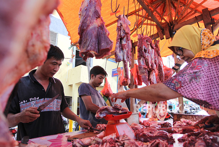 Calon pembeli menimbang daging sapi di pasar tradisional (ilustrasi).