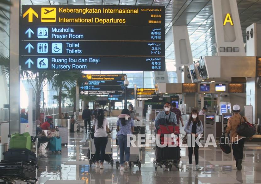 Calon penumpang berjalan di selasar terminal untuk lapor diri di Terminal 3 Bandara Soekarno Hatta, Tangerang, Banten, Rabu (29/12/2021). Pemerintah melarang warga negara Indonesia (WNI) bepergian keluar negeri sementara waktu untuk mengantisipasi penyebaran COVID-19 varian Omicron.