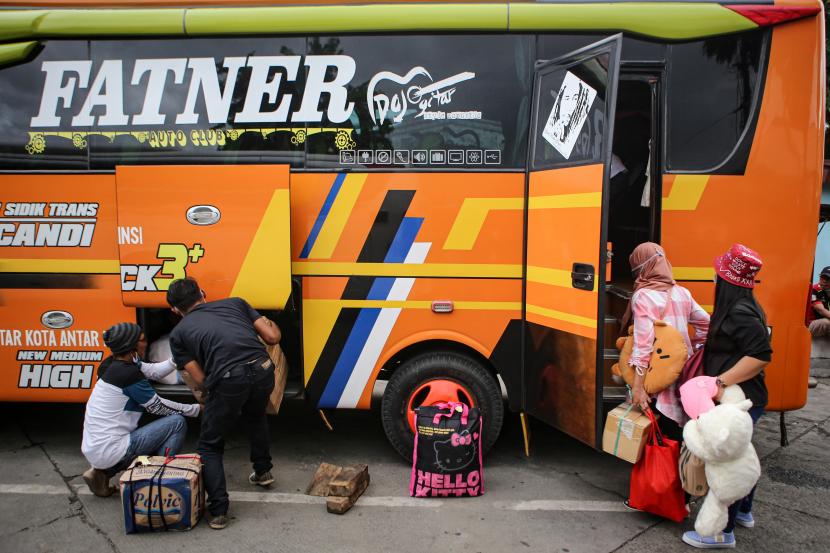 Calon penumpang bersiap masuk ke dalam bus di Terminal Kalideres, Jakarta, Ahad (20/12/2020). Menjelang Natal dan Tahun Baru 2021, terminal tersebut terpantau ramai.
