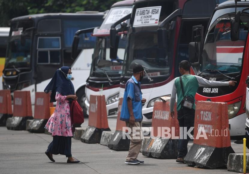 Calon penumpang bus antar kota antar provinsi (AKAP) yang mengenakan masker bersiap menaiki bus di Terminal Kampung Rambutan, Jakarta.