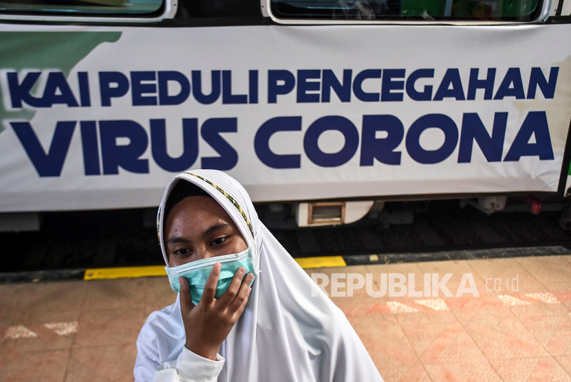 Calon penumpang kereta api beraktivitas di samping kereta inspeksi yang dipasang iklan sosialisasi pencegahan penyebaran virus corona (Covid-19) di Stasiun Bandung, Kota Bandung, Kamis (5/3).