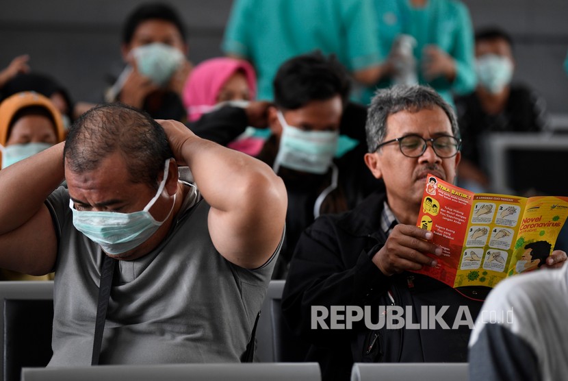 Calon penumpang kereta api membaca pamflet sosialisasi pencegahan penyebaran virus corona di Stasiun Pasar Senen, Jakarta, Senin (9/3). Kewaspadaan komunitas diperlukan untuk mengendalikan penyebaran virus corona.