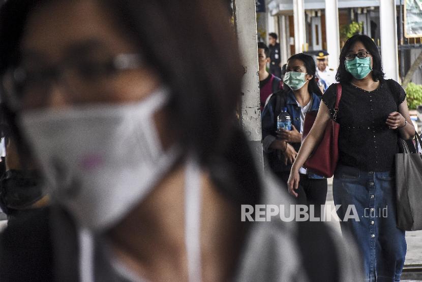  Calon penumpang kereta api mengenakan masker di Stasiun Bandung, Kota Bandung, Ahad (15/3). (Republika/Abdan Syakura)
