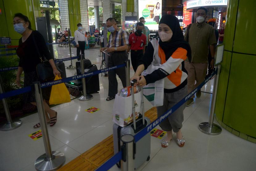 Calon penumpang kereta berjalan menuju pemeriksaan tiket di Stasiun Gambir, Jakarta, Ahad (24/4/2022).