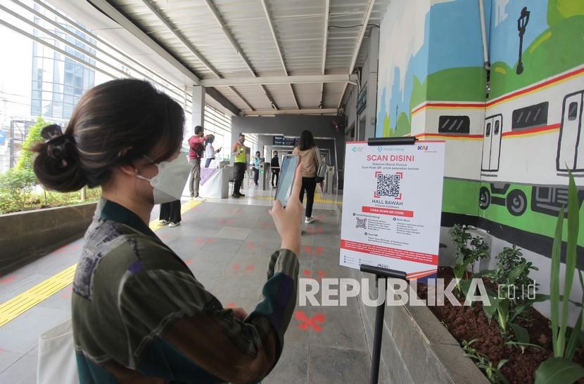 Calon penumpang memindai kode batang (QR Code) melalui aplikasi PeduliLindungi sebelum memasuki Stasiun Sudirman, Jakarta, Sabtu (11/9/2021). KAI Commuter memastikan kapasitas penumpang saat ini masih dibatasi. 