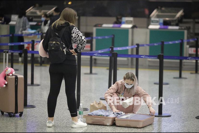 Calon penumpang mengenakan masker di terminal Bandara Guangzhou, Provinsi Guangdong, China.