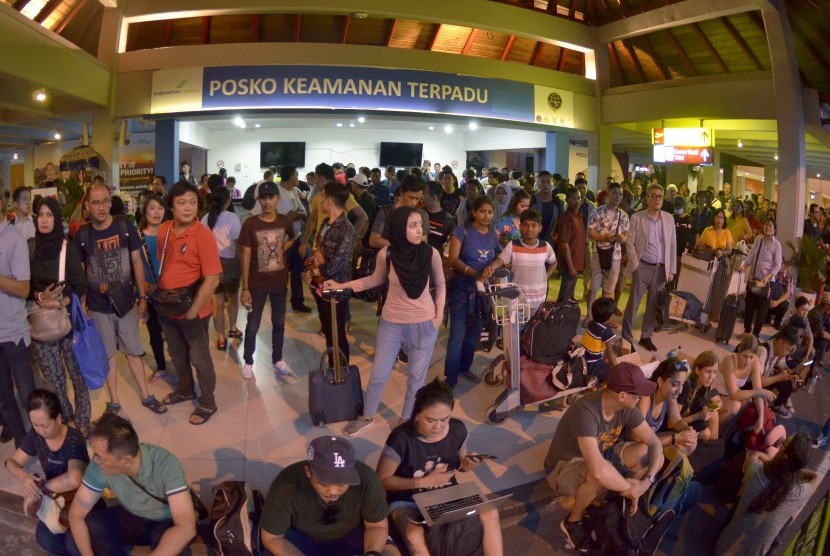 Calon penumpang menunggu jadwal penerbangan saat terjadi kebakaran di kawasan Terminal Keberangkatan Domestik Bandara Internasional I Gusti Ngurah Rai, Bali, Jumat (19/4/2019).