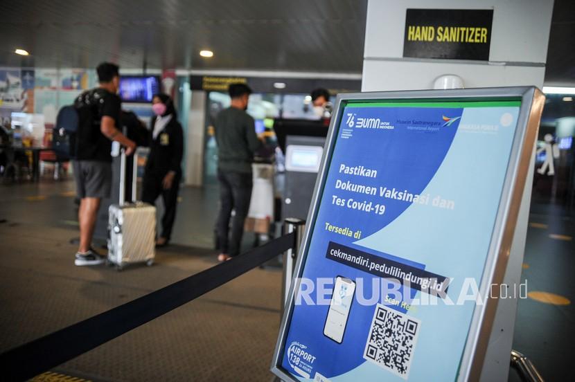 Calon penumpang menunjukan dokumen perjalanan kepada petugas di Bandara Husein Sastranegara, Bandung, Jawa Barat, Selasa (15/2/2022). Pemerintah berencana akan mengurangi durasi karantina bagi pelaku perjalanan luar negeri menjadi tiga hari pada 1 Maret 2022 mendatang. 