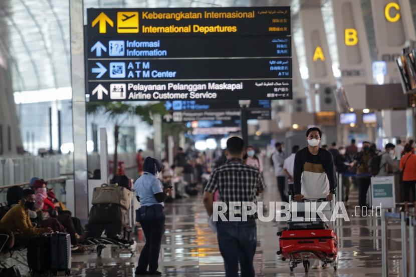 Calon penumpang pesawat berjalan di area Terminal 3 Bandara Internasional Soekarno Hatta, Tangerang, Banten, Selasa (21/9). Pemerintah resmi mengatur pelaku perjalanan udara di Pulau Jawa dan Bali serta daerah PPKM level 3 dan 4 wajib menyertakan surat keterangan negatif tes PCR. 