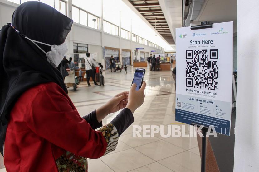 Calon penumpang pesawat melakukan scan QR code melalui aplikasi PeduliLindungi di Bandara Internasional Juanda Surabaya di Sidoarjo, Jawa Timur, Jumat (6/8/2021). didorong oleh status level PPKM yang berangsur turun dari level 4 ke level 3 di Pulau Jawa Bali
