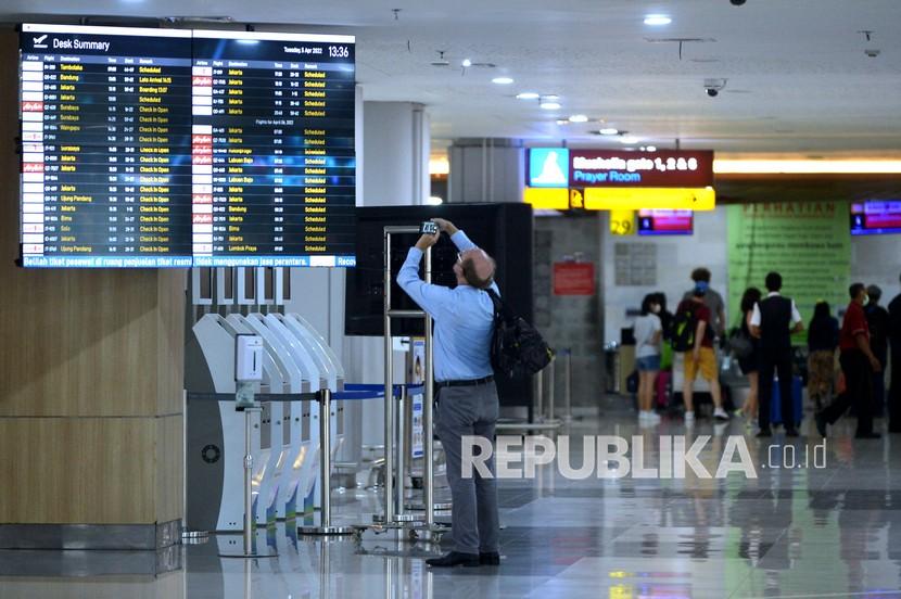 Calon penumpang pesawat melihat jadwal penerbangan di Terminal Domestik Bandara Internasional I Gusti Ngurah Rai, Kabupaten Badung, Bali, Selasa (5/4/2022).