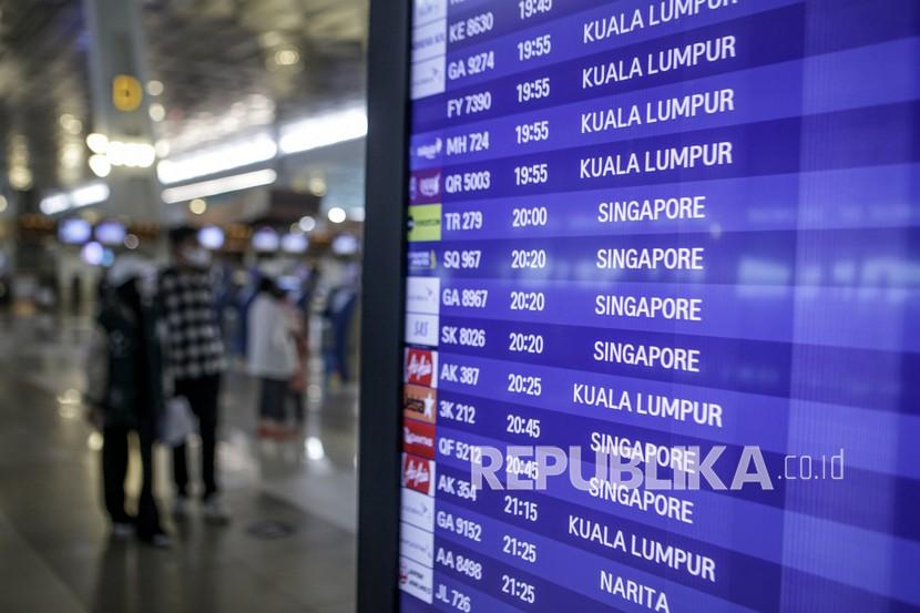 Calon penumpang pesawat melintas di samping papan jadwal penerbangan di Terminal 3 Bandara Internasional Soekarno-Hatta, Tangerang, Banten. AP II berencana memasang PLTS di tujuh bandara termasuk Soekarno Hatta