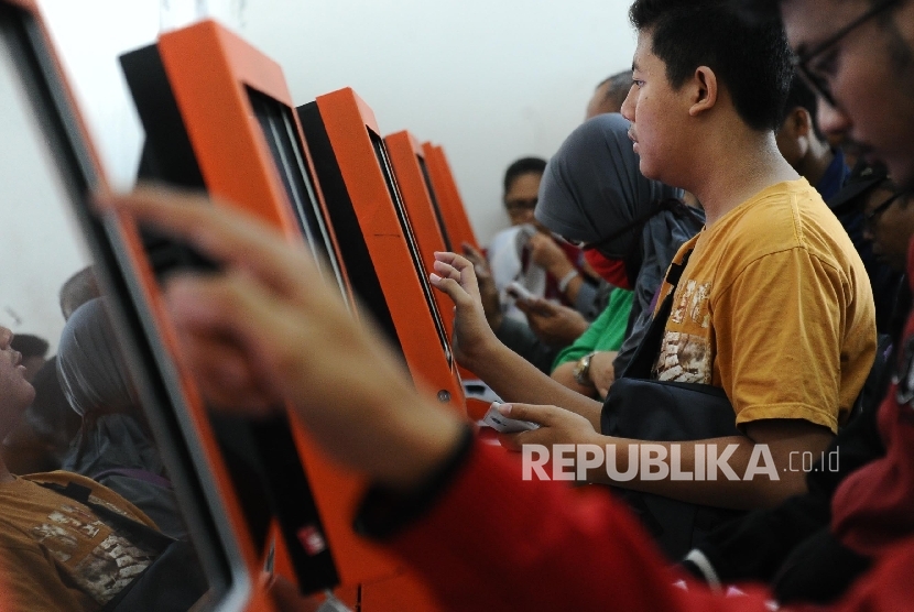 Calon penumpang sedang mengantri saat sedang mencetak tiket kereta di Stasiun Senen, Jakarta, Jumat (1/4). Pembelian tiket untuk mudik Lebaran atau H-90 hari sebelum hari pemberangkatan sudah dapat dibeli namun terdapat beberapa ketentuan, di antaranya set
