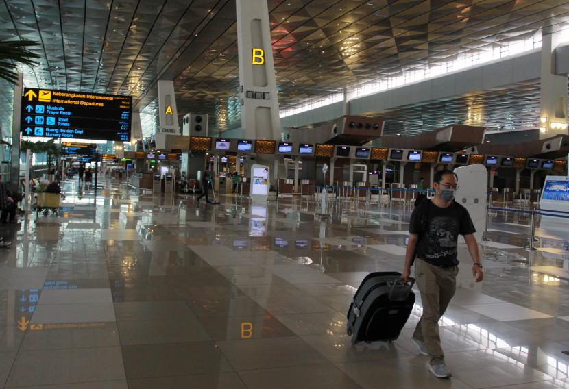 Calon penumpang WNA melintas di area keberangkatan Internasional yang terlihat lengang di Terminal 3 Bandara Soekarno Hatta, Tangerang, Banten, Rabu (1/4/2020). Pemerintah lewat Kementerian Hukum dan Hak Asasi Manusia resmi melarang masuk dan transit bagi Warga Negara Asing (WNA) yang akan berkunjung ke Indonesia, larangan tersebut berlaku mulai tanggal 2 April 2020 hingga batas yang belum ditentukan yang bertujuan untuk menekan penyebaran COVID-19.