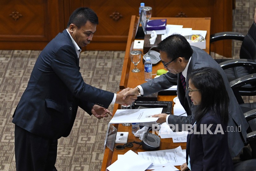 Calon pimpinan KPK Nawawi Pomolango (kiri) menjabat tangan pimpinan sidang Komisi III DPR RI Herman Hery (tengah) usai menjalani uji kepatutan dan kelayakan di ruang rapat Komisi III DPR RI, Jakarta, Rabu (11/9/2019). 