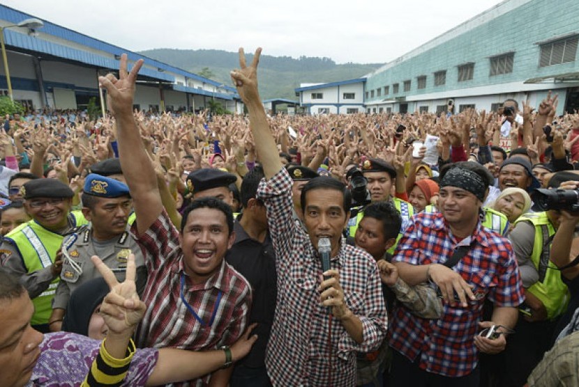 Calon preside nomor urut dua Joko Widodo (tengah) mengacungkan salam dua jari ketika kampanye terbuka di depan ribuan buruh di PT Daehan Global, Kawasan Berikat Cibadak, Sukabumi, Jawa Barat, Rabu (2/7).