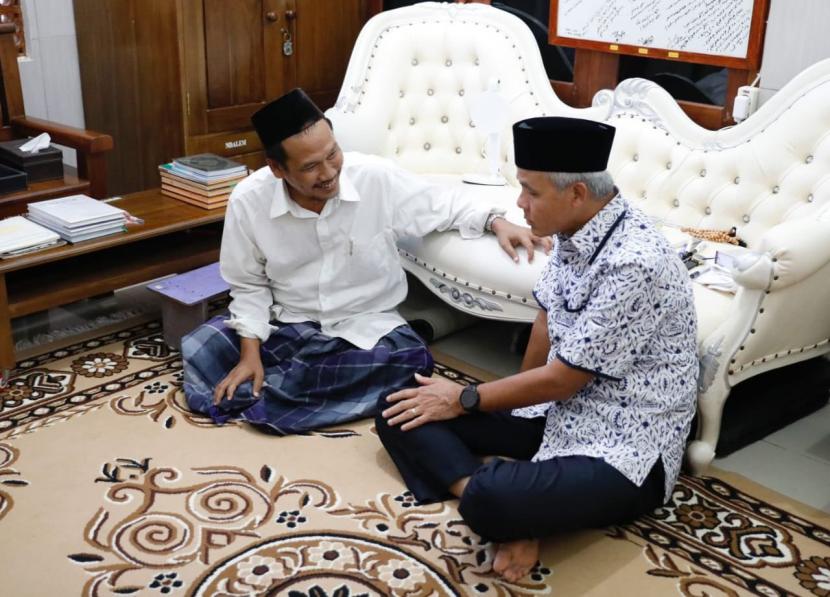 Calon presiden (capres) PDIP Ganjar Pranowo memajang foto sedang mengobrol dengan KH Ahmad Bahauddin Nursalim alias Gus Baha di Rembang, Jawa Tengah, Kamis (4/5/2023).