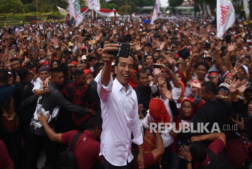 Calon Presiden Joko Widodo (tengah) berswafoto dengan massa Forum Alumni Jawa Timur di Surabaya, Jawa Timur, Sabtu (2/2/2019).