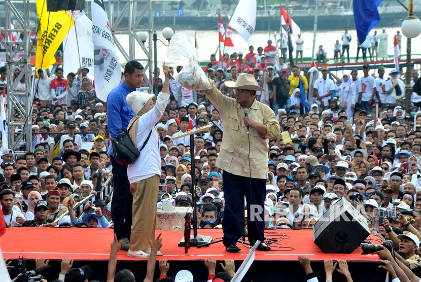 Calon Presiden nomer urut 02 Prabowo Subianto menerima sumbangan dari perwakilan emak-emak Palembang di hadapan pendukung dan simpatisan yang memadati pelataran Benteng Kuto Besak Palembang pada Kampanye akbar, di Palembang, Sumsel, Selasa (9/4/2019). 