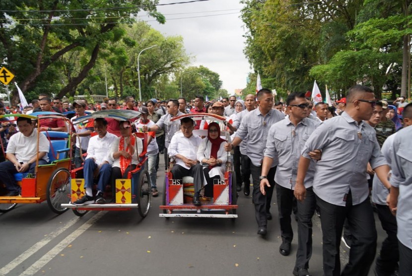 Calon presiden nomor urut 01 Joko Widodo didampingi  Iriana Jokowi bersama Ketua Dewan Pengarah Tim Kampanye Nasional Jokowi-Ma'ruf Jusuf Kalla dan Ibu Mufidah Jusuf Kalla dan Ketua TKN Erick Thohir naik becak menuju Lapangan Karebosi, Makassar, Ahad (31/3).