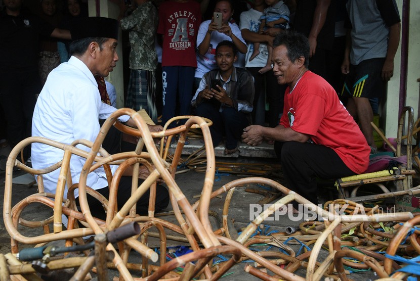 Calon presiden nomor urut 01 Joko Widodo (kiri) berbincang dengan perajin ketika mengunjungi industri rotan rumahan di Tegalwangi, Kabupaten Cirebon, Jawa Barat, Jumat (5/4/2019). 