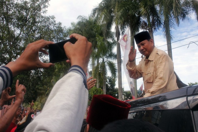 Calon Presiden nomor urut 02 Prabowo Subianto menyapa pendukungnya dari atas mobil saat berkampanye di Serang, Banten, Sabtu (16/3/2019).