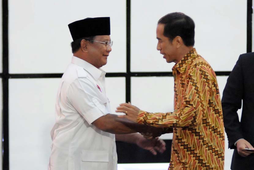 Calon presiden nomor urut satu, Prabowo Subianto (kiri) dan calon presiden nomor urut dua Joko Widodo (kanan) berjabat tangan jelang debat di Hotel Holiday Inn, Kemayoran, Jakarta, Ahad (22/6).