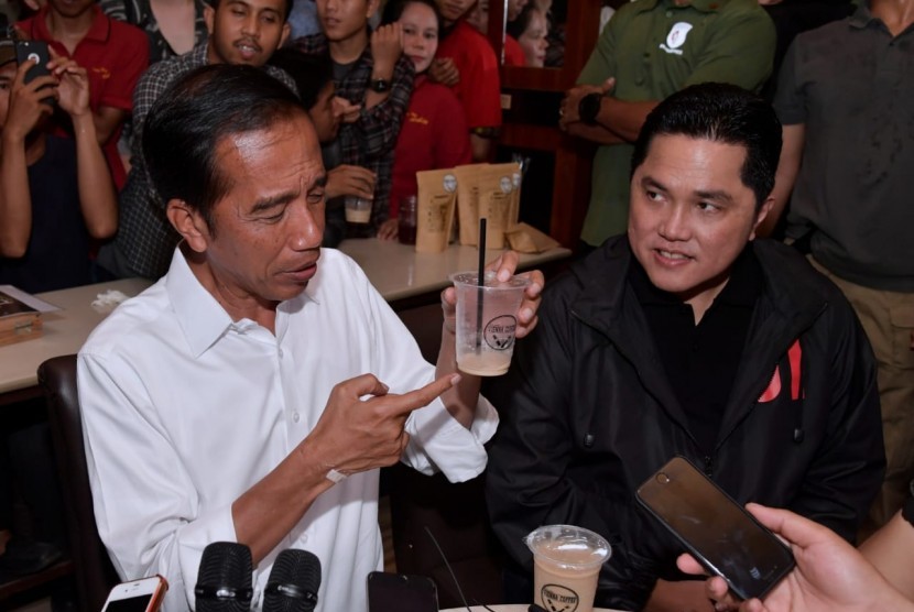Calon presiden pejawat Joko Widodo (kanan) dan Ketua Tim Kampanye Nasional Jokowi-Ma'ruf Amin, Erick Thiohir, ketika mencicipi kopi lokal di Dumai.