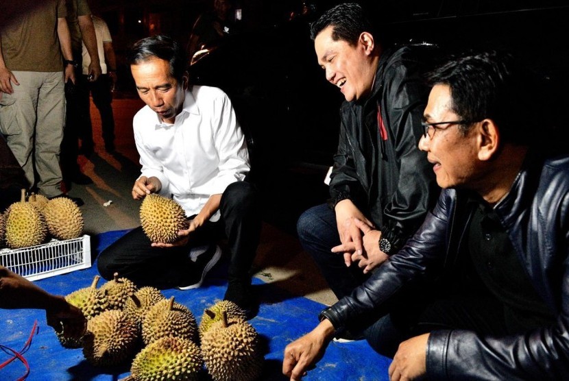Calon presiden pejawat Joko Widodo memborong durian dari pedang pinggir jalan di Dumai.