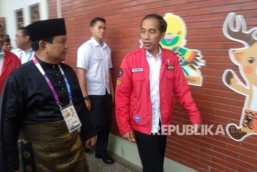 Presiden Joko Widodo bersama Ketua Umum Pengurus Besar Ikatan Pencak Silat Seluruh Indonesia Prabowo Subianto dan Pesilat Indonesia Hanifan Yudani Kusumah berpelukan usai pertandingan cabang olahraga silat Asian Games 2018 di Padepokan Pencak Silat TMII, Jakarta, Rabu (29/8).