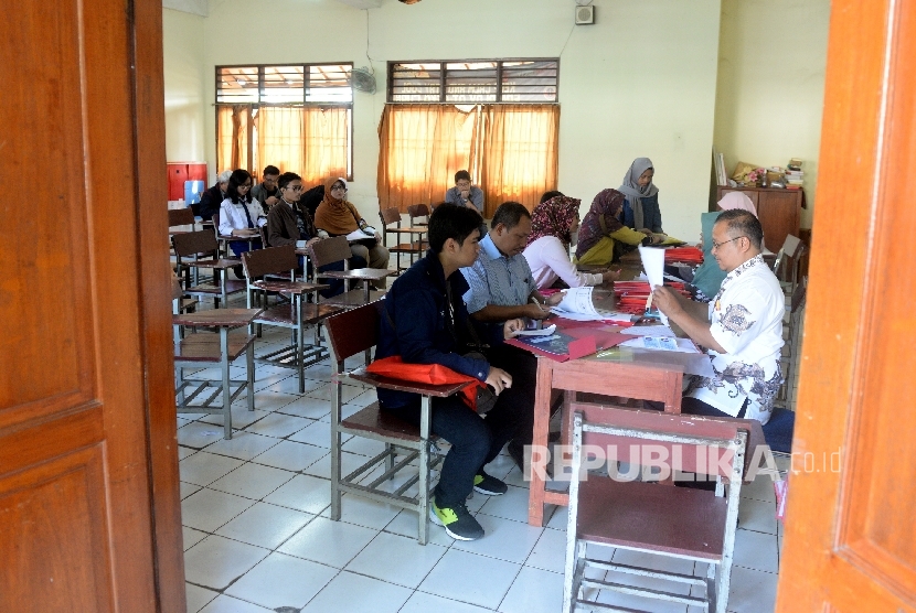  Calon siswa dan Orang tua wali melakukan pendaftaran ulang sebelum kegiatan belajar mengajar di SMA 6 Depok, Jawa Barat, Rabu (12/7). 